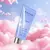 Embalagem do hidratante corporal Heaven Brand Collection N° 168 em tubo lilás com tampa prateada, sobre fundo de nuvens cor-de-rosa e céu azul