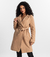Mulher usando o Trench Coat Essencial bege da MR & Co., modelo atemporal e sofisticado com faixa para ajuste e caimento fluido. Confeccionado em moletom felpado de menor impacto, combina conforto térmico com design minimalista e sustentável.
