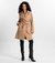 Mulher usando o Trench Coat Essencial bege da MR & Co., modelo atemporal e sofisticado com faixa para ajuste e caimento fluido. Confeccionado em moletom felpado de menor impacto, combina conforto térmico com design minimalista e sustentável.