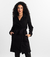 Mulher vestindo o Trench Coat Essencial preto da MR & Co., peça minimalista e elegante feita em moletom felpado com toque macio. Casaco confortável e versátil com gola dupla, ideal para dias frios com estilo e propósito. Moda consciente com menos impacto 
