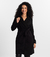 Mulher vestindo o Trench Coat Essencial preto da MR & Co., peça minimalista e elegante feita em moletom felpado com toque macio. Casaco confortável e versátil com gola dupla, ideal para dias frios com estilo e propósito. Moda consciente com menos impacto 