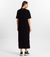 Mulher vestindo o Vestido Longo Essencial preto da MR & Co., feito em algodão sustentável com caimento reto e confortável. Uma peça minimalista e atemporal, ideal para quem busca moda consciente, estilo versátil e elegância no dia a dia.