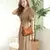 Modelo feminina vestindo bege e usando bolsa hobo marrom usando a alça transversal, destacando o estilo casual e a alça longa transversal ajustada.