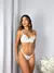 Mulher usando conjunto de lingerie branco sem bojo em renda com detalhes delicados