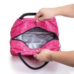 Lonchera térmica rosa con estampado de Barbie, interior aislante visible y asas negras sostenida por dos manos