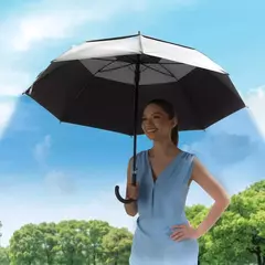 Mujer sonriente sosteniendo una sombrilla de colores blanco y negro en un día soleado.