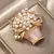 Imagem do Broche em formato de flor com pérolas e detalhes delicados. Design elegante da Wuli & Baby, ideal para uso feminino ou unissex em festas escritório.