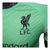Detalhe da camisa de goleiro verde do Liverpool 25/26 com o escudo L.F.C. em preto no peito