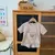 Imagem do Conjunto Bebê Menino em Waffle – Com Bolso e Ursinho (12m a 3 anos) Conjunto leve e macio em tecido waffle, ideal para o verão. Camiseta com bolso frontal e shorts com estampa fofa de ursinho. Disponível em duas cores lindas para meninos de 1 a 3 anos.