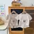 Conjunto Bebê Menino em Waffle – Com Bolso e Ursinho (12m a 3 anos) Conjunto leve e macio em tecido waffle, ideal para o verão. Camiseta com bolso frontal e shorts com estampa fofa de ursinho. Disponível em duas cores lindas para meninos de 1 a 3 anos. - Haru & Koda