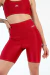 Close-up lateral do Short Fitness Vermelho Divino da Callisa, mostrando o bolso lateral funcional e o cós de cintura alta que modela o corpo.
