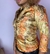 Blazer feminino Iracema Carvalho e Thomaz com estampa barroca em tons de dourado, laranja e marrom, usado por modelo