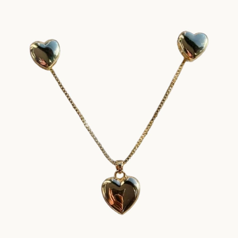Colar dourado de corrente fina com pingente de coração liso e polido e um par de brincos em formato de coração.