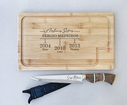 Tábua retangular de madeira personalizada para churrasco com faca SG Churrasco, exibindo gravação com nomes e datas, ideal para presentear pais.