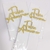 Topo de bolo com a frase "Feliz aniversário" em glitter dourado, embalado em pacote transparente.