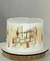 Bolo de aniversário decorado com pintura em tons de dourado e prata, apresentando um topo de bolo "Happy Birthday" em papel.
