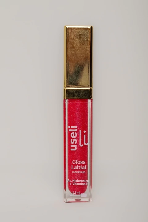 Gloss labial vermelho com brilho da marca Useli com tampa dourada