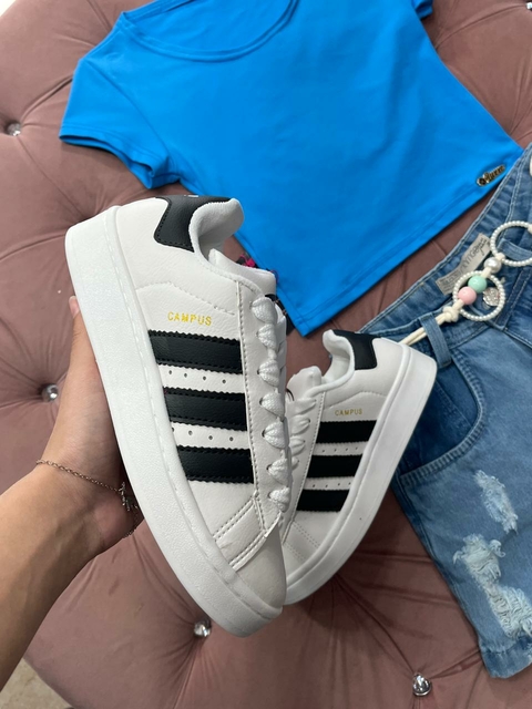Tênis branco com listra preta e detalhes dourado