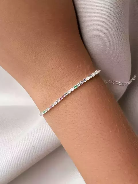 Pulseira Riviera colorida banhada a prata no pulso, com pedras brilhantes em tons variados