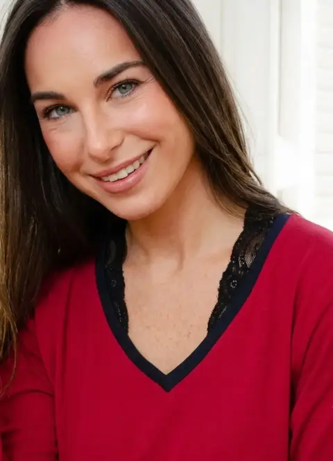 Mujer sonriente con pijama Viviana de remera bordo con detalle de encaje negro en el escote y vivo en microfibra negro
