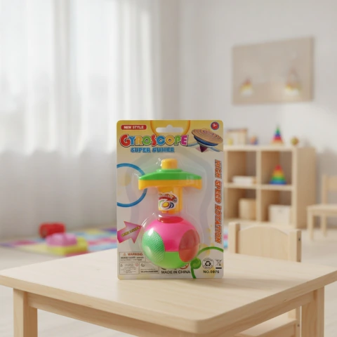 Trompo bola de juguete con luz, colores verde, rosa y amarillo, en blister sobre mesa de madera en habitación infantil