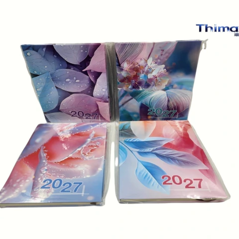 Cuatro agendas A5 2027 con cubiertas decoradas con hojas y flores en tonos pastel y detalles de gotas de agua