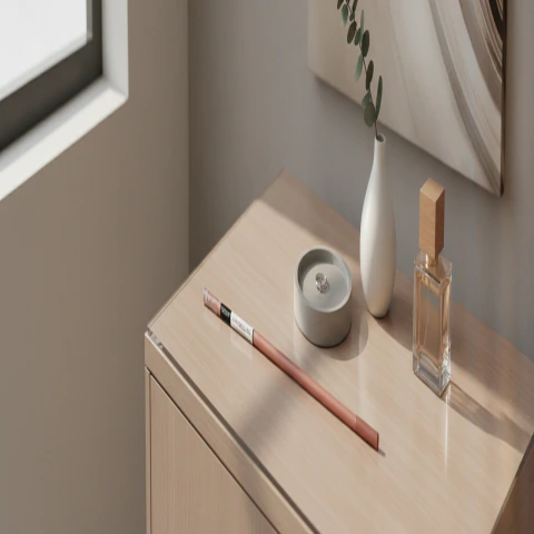 Barra de ducha extensible color cobre sobre mueble de madera con jarrón blanco, vela y perfume