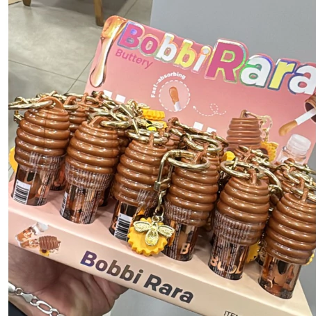 BRB-021-58 - LIP OIL COM PINGENTE GIRASSOL - BOBBI RARA