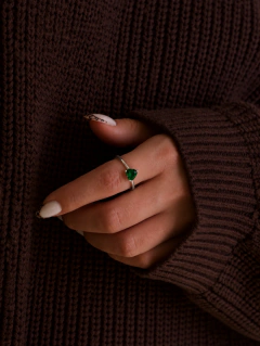 Anillo de plata con piedra verde puesto en la mano