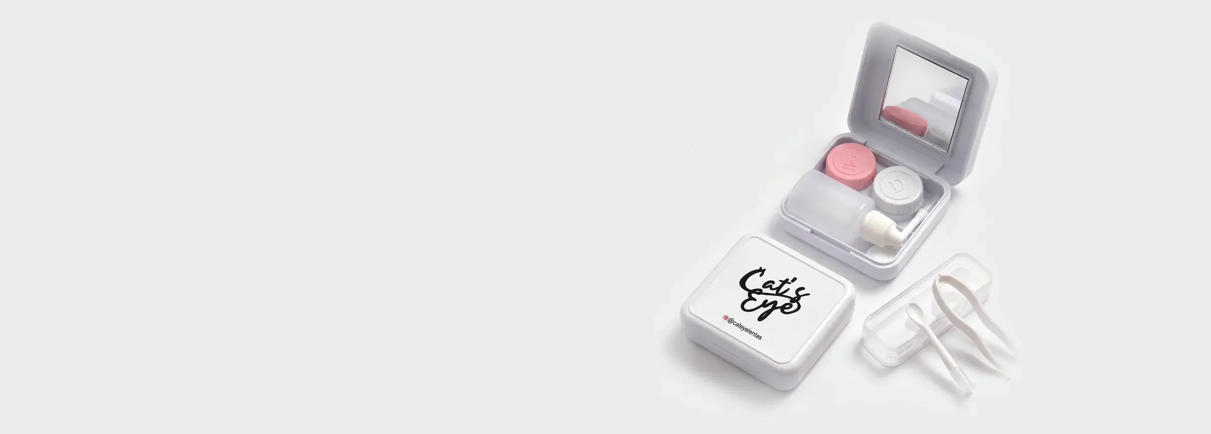 Kit de viagem aberto com espelho, frasco e porta-lentes, estojo quadrado da Cat's Eye e estojinho com aplicador e pinça