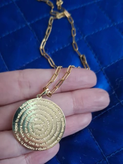 Collar enchapado en oro con medalla circular que tiene grabado el texto del Padre Nuestro en espiral.