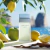 Frasco de perfume Dolce&Gabbana Light Blue Eau de Toilette ao ar livre com maçã verde, limões e fundo de mar e céu azul
