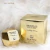 Frasco e embalagem dourados do perfume feminino Dream Brand Collection Lady B Nº 105, inspirado no Lady Million de Paco Rabanne, com design facetado semelhante a um diamante.