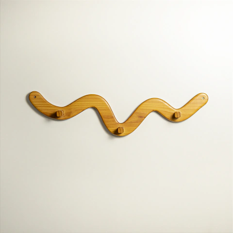 Cabideiro de parede Jabaquara de madeira, com formato ondulado moderno e quatro ganchos, ideal para organizar roupas e acessórios.