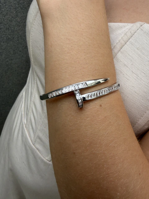 Pulseira prateada com detalhe central cravejado