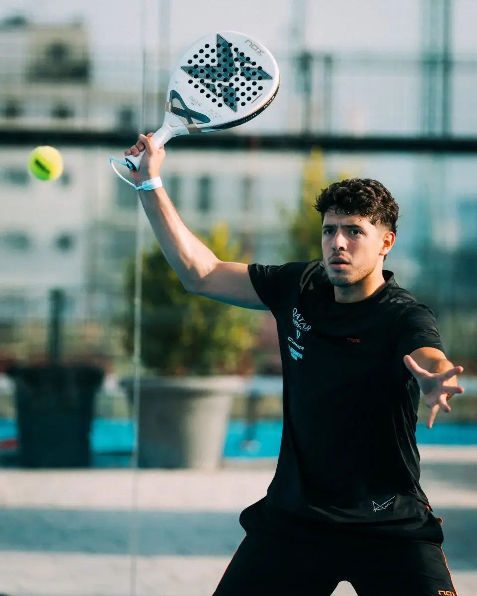 Jugador de pádel rematando con pala Nox