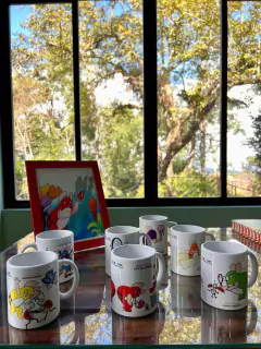 DOIS LIVROS E UMA CANECA DOS PERSONAGENS OS PINGOS