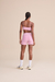 Mulher vista de costas usando shorts fit Live! rosa dazzle fitness e top fit Live! rosa dazzle esportivo combinando.