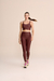 Modelo usando legging marrom da linha fitness Live!, com top combinando e tênis esportivos, em fundo neutro.