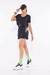 Mulher vestindo camiseta dry fitness cropped preta da Di Paula Dila com shorts pretos e boné prto