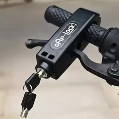 Traba antirrobo para moto colocada en el manubrio, con llave insertada en el cilindro de bloqueo