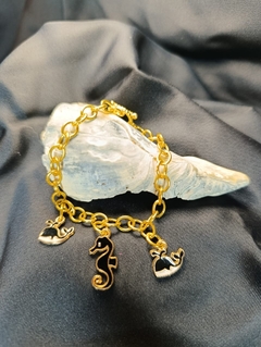 Pulsera dorada con dijes negros