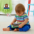 Niño pequeño sentado en el suelo jugando con la tablet educativa Fisher Price Rie y Aprende