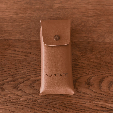 estuche para anteojos o anteojos de sol de forma rectangular tipo lapicero de cueron sintetico color habano marca Nomade fondo madera