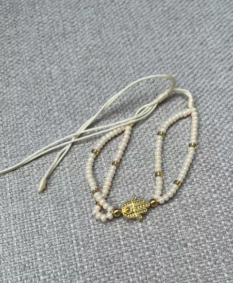 pulsera doble blanca con mano dorada