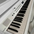 Piano digital de cauda Medeli Grand 510 Branco na cor branca, com teclas pretas e brancas visíveis.