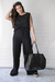 Modelo sosteniendo un bolso negro llamado Cookies, vistiendo un conjunto negro.