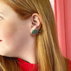 detalhe na modelo do brinco semijoia earcuff setas cravejado de zircônias esmeraldas banhado a ródio negro