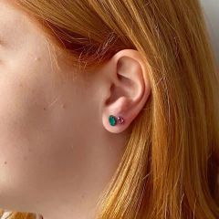 detalhe na orelha do kit de 3 brincos losango cores esmeralda e rubi, e redondo na cor branco leitoso banhados a ródio negro