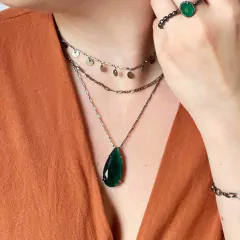 detalhe na modelo do colar semijoia em gota cristal calcedônia cor esmeralda banhado a ródio negro